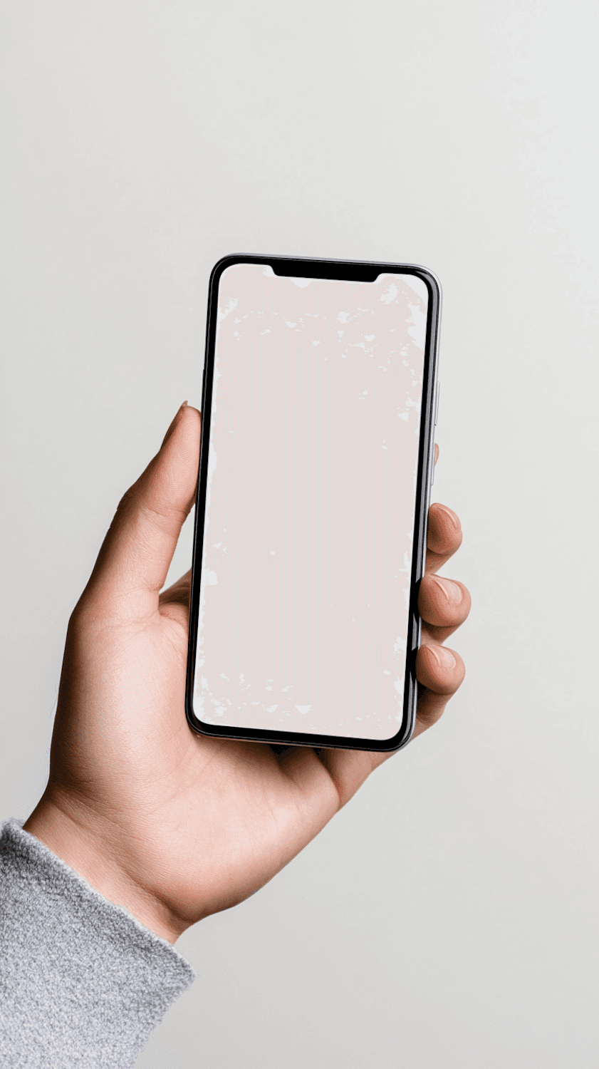 A hand holding a smartphone against a pale grey wall